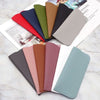 Colección de fundas para gafas de cuero PU en varios tonos: rojo, azul, verde, marrón y rosa, mostradas sobre un fondo blanco