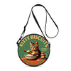 A round green and yellow graphic featuring a cat and biscuits on a black strap bag.