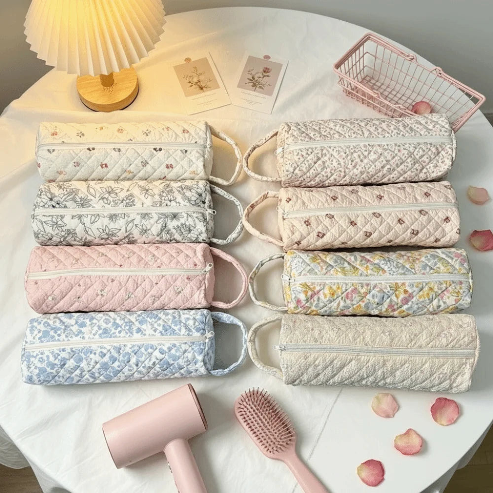 A collection of quilted storage bags in various pastel colors and patterns for hair dryers and personal items.