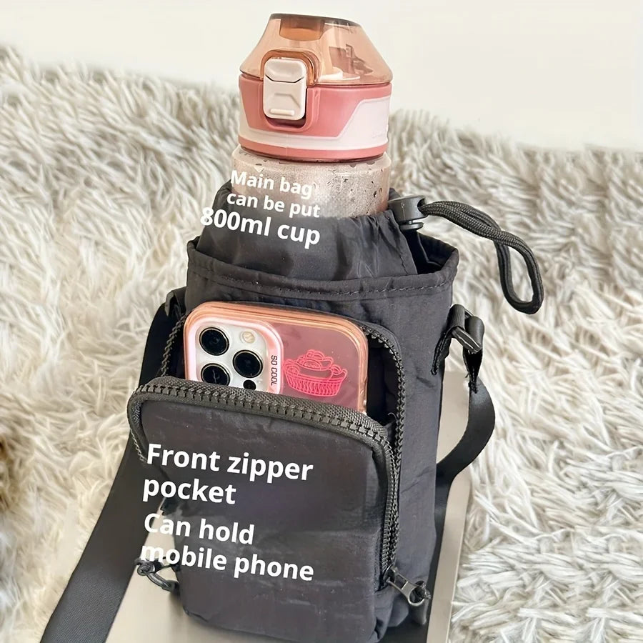 A dark fabric bag is shown carrying a water bottle and featuring a front zipper pocket for a mobile phone.