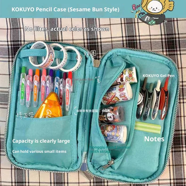 A teal KOKUYO pencil case with a fold-out tray showing various pens and pencils inside.