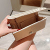 A hand holds a beige luxury chain shoulder clutch bag with a striped leather strap.