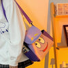 A purple and yellow Dora The Explorer cartoon flannel backpack is displayed on a wooden shelf.