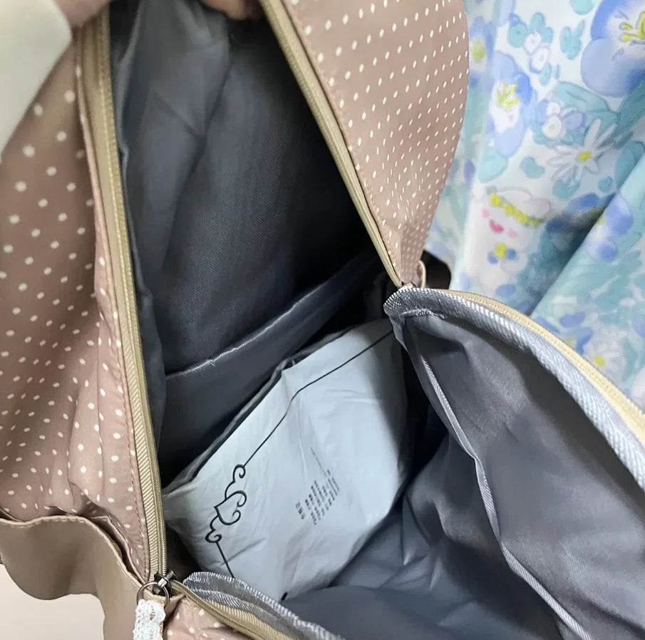 A close-up view of a light beige backpack with white polka dots, showing the interior lining and zipper details.
