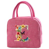 A pink insulated canvas lunch bag decorated with colorful floral and butterfly embroidery.