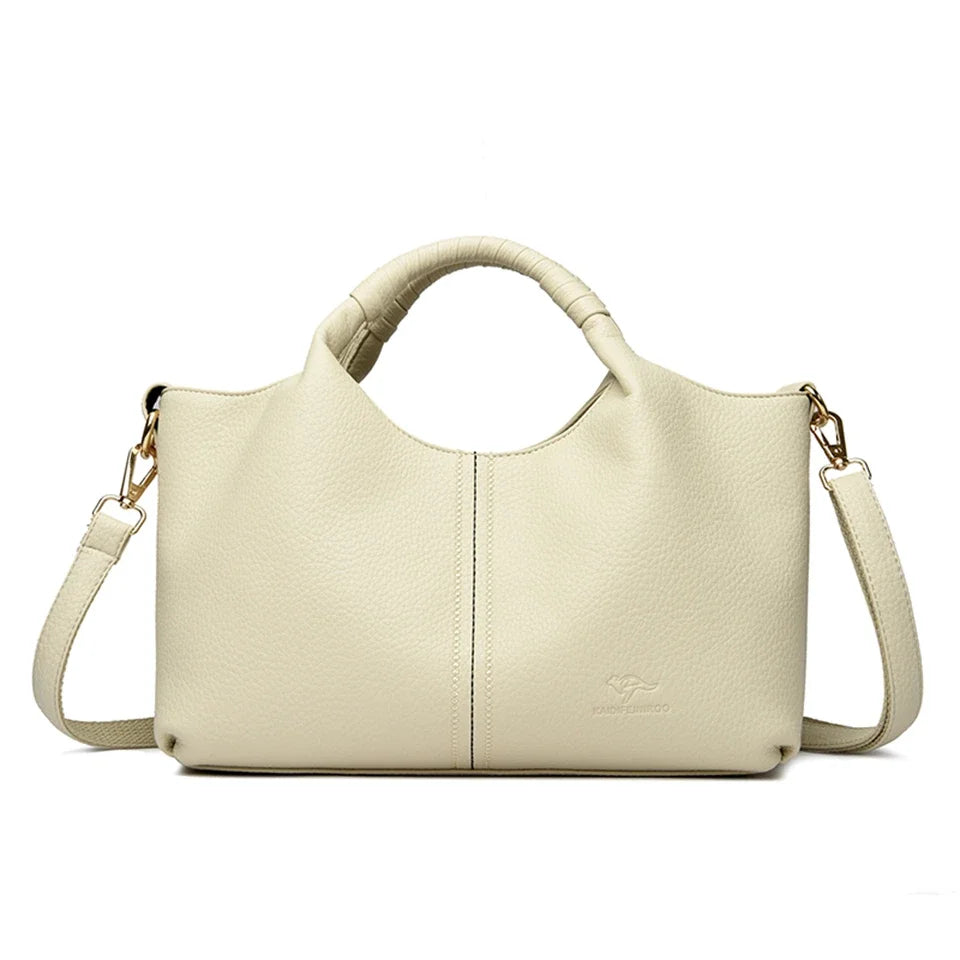 A beige luxury soft leather women's tote bag with a handle and shoulder strap.