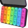 A weekly pill organizer with colored compartments for Sun through Sat, designed for travel.