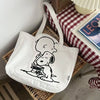 White canvas shoulder bag featuring a black line drawing of Snoopy