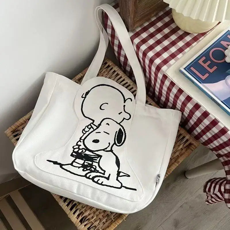 White canvas shoulder bag featuring a black line drawing of Snoopy