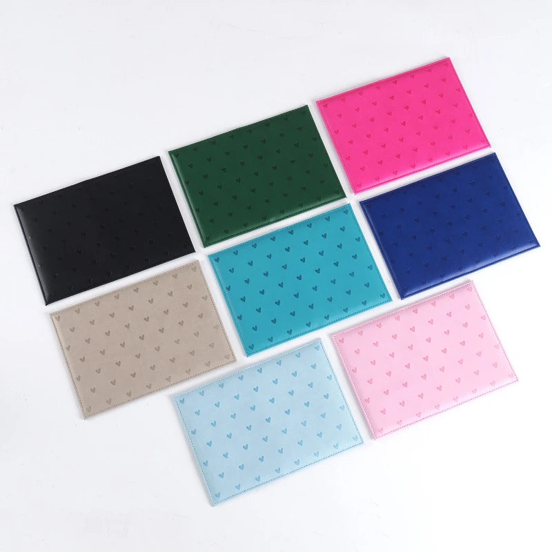 A set of six heart print passport covers in various colors including green, pink, blue, purple, black, and beige.