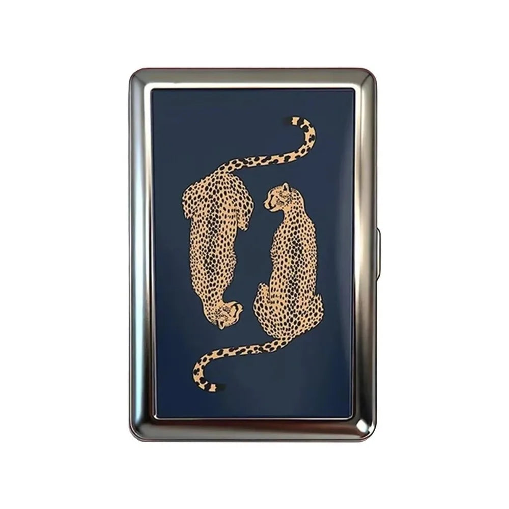 A vintage snap metal card holder with a dark blue surface featuring a gold leopard print silhouette.
