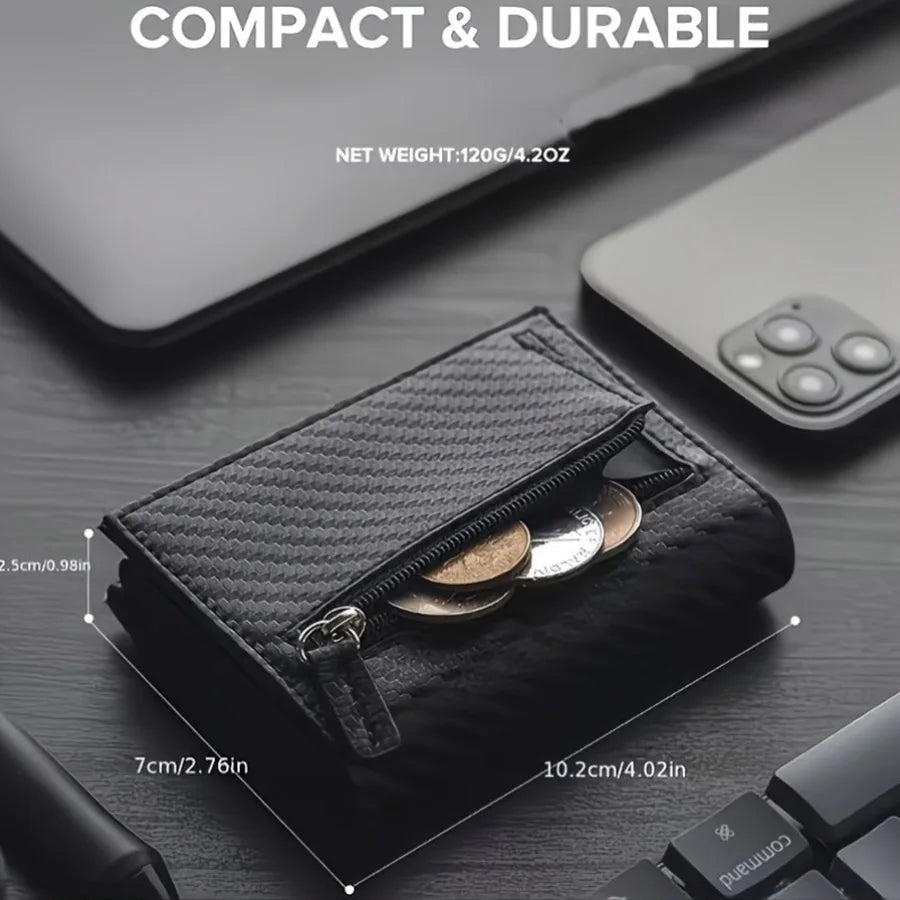 A dark gray slim aluminum pop-up card holder with a zippered compartment shown on a wooden surface.