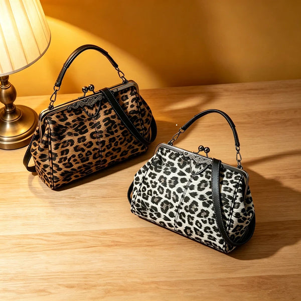 A black and white leopard print faux leather handbag with a top handle and crossbody strap resting on a wooden surface.