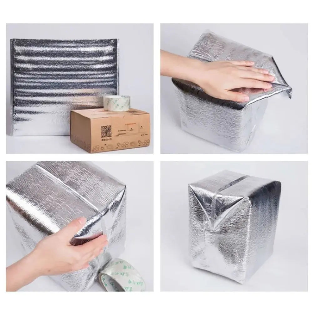 A hand is opening an insulated thermal food delivery bag with a silver aluminum foil lining.