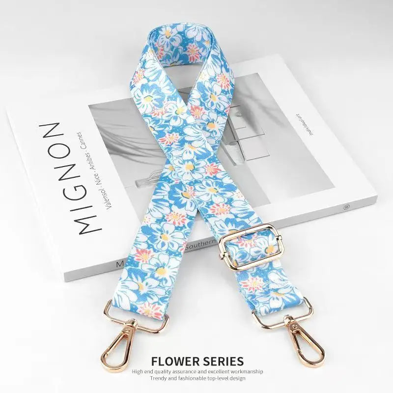 A blue floral patterned nylon bag strap is displayed on a white box.