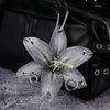 A realistic silver-gray orchid flower keychain hanging from a black leather bag.