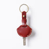A genuine leather key fob cover with a keychain ring and a metal key attached.
