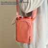 A pink water bottle carrier bag with a zippered pocket is shown attached to a white knitted garment.