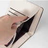 A hand is opening a beige fashion PU leather slim card holder wallet, showing the interior.