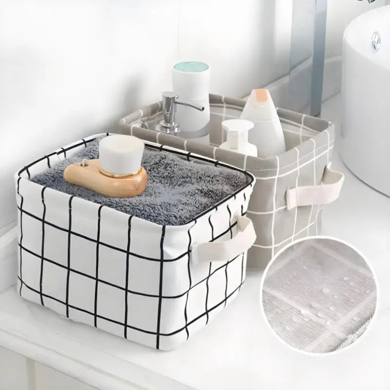 A white storage basket with a black grid pattern holds various bathroom or desk items like soap and lotion bottles.