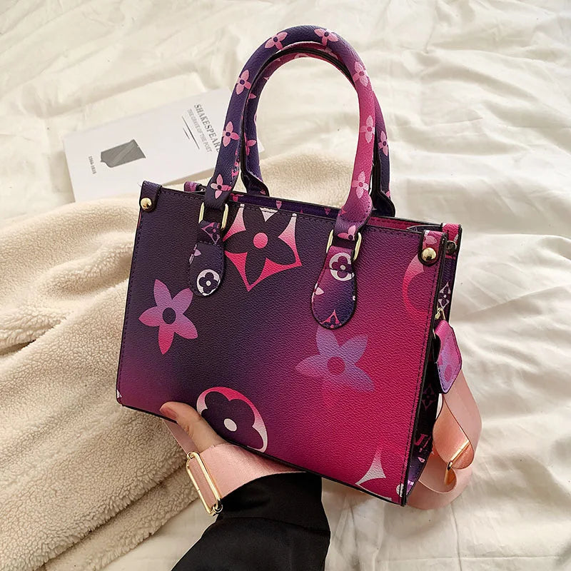 A purple ladies' shoulder tote bag with pink floral patterns resting on a white blanket.