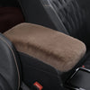 A plush brown armrest cushion set is shown inside a black car seat, featuring quilted leather upholstery.
