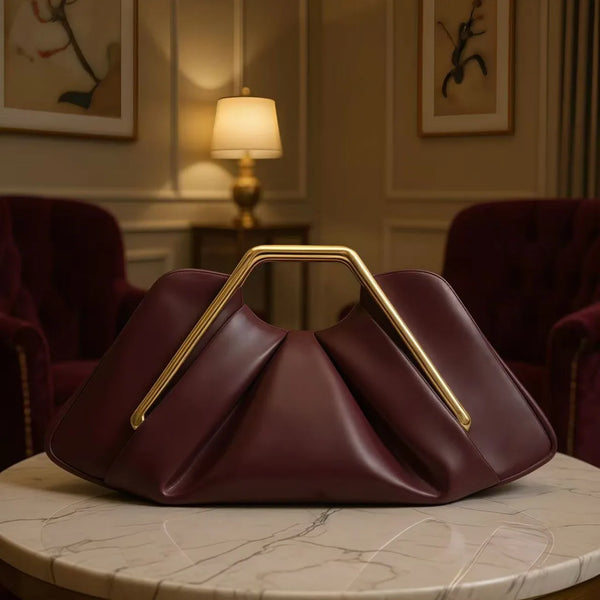Dunkelburgunderes Soft-PU-Leder-Crossbody-Taschen mit Gold-Hardware auf Marmor