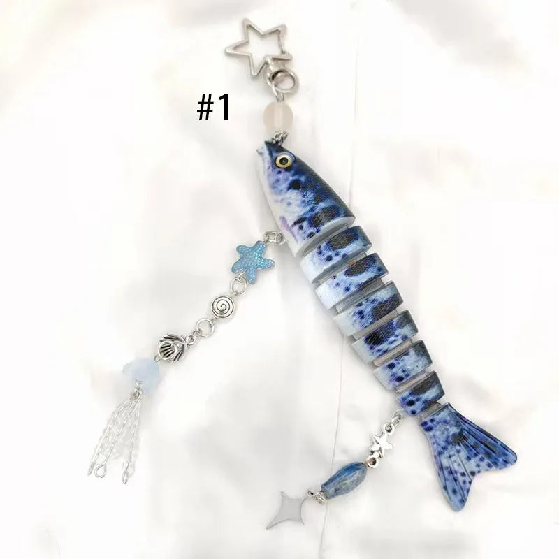 A blue and white fish-themed acrylic keychain charm with a silver star topper.