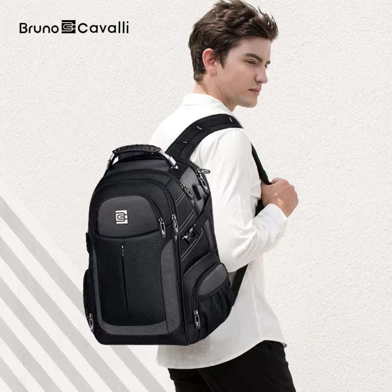 A man wearing a white shirt is holding a black durable men's laptop backpack.