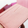 Gros plan sur un porte-cartes en cuir véritable rose, gravé sur mesure et texturé.