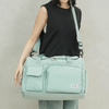 A light mint green quilted portable travel duffle bag worn by a person.