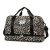 A brown and black leopard print travel duffel bag with a padded shoulder strap.