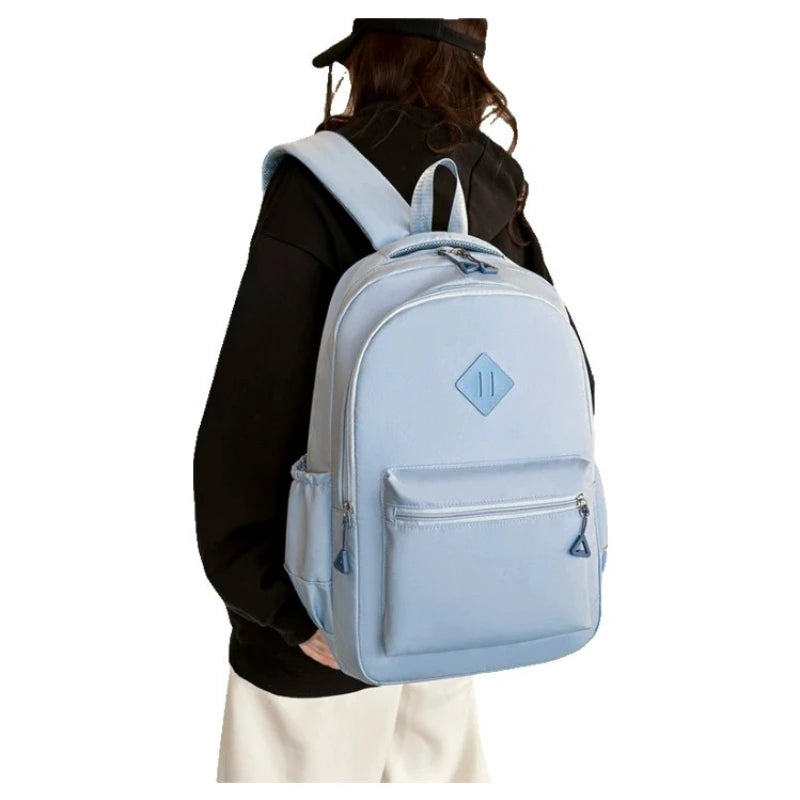 A light blue durable nylon commuter backpack worn by a person.