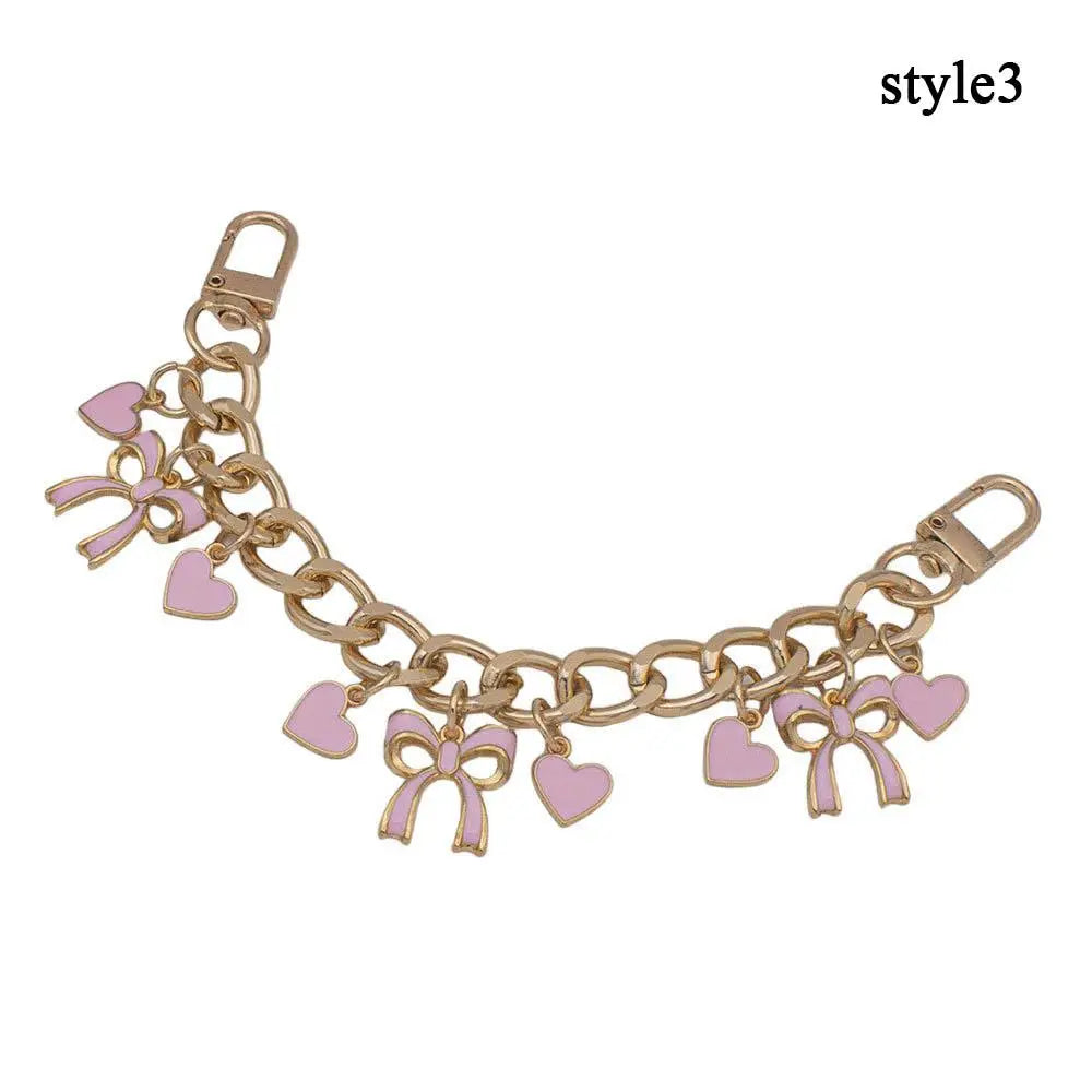 Accesorio de bolso dorado con cadena, corazones de esmalte y adornos de flor de cerezo.