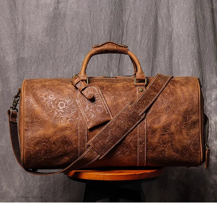 Braune Vintage-Leder-Tasche mit Ledergriff und Trageriem auf Holzoberfläche.