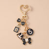 Gold enamel heart keychain featuring a black heart charm and the number five.