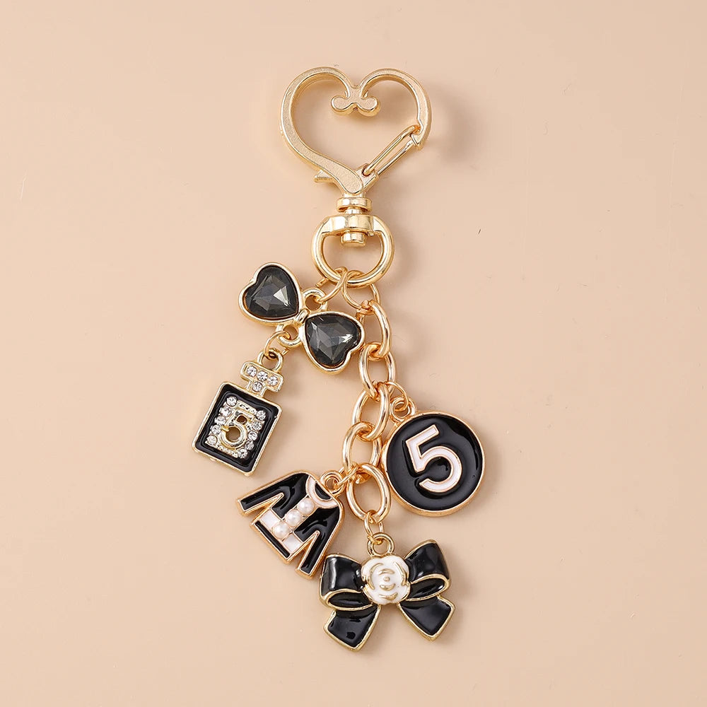 Gold enamel heart keychain featuring a black heart charm and the number five.