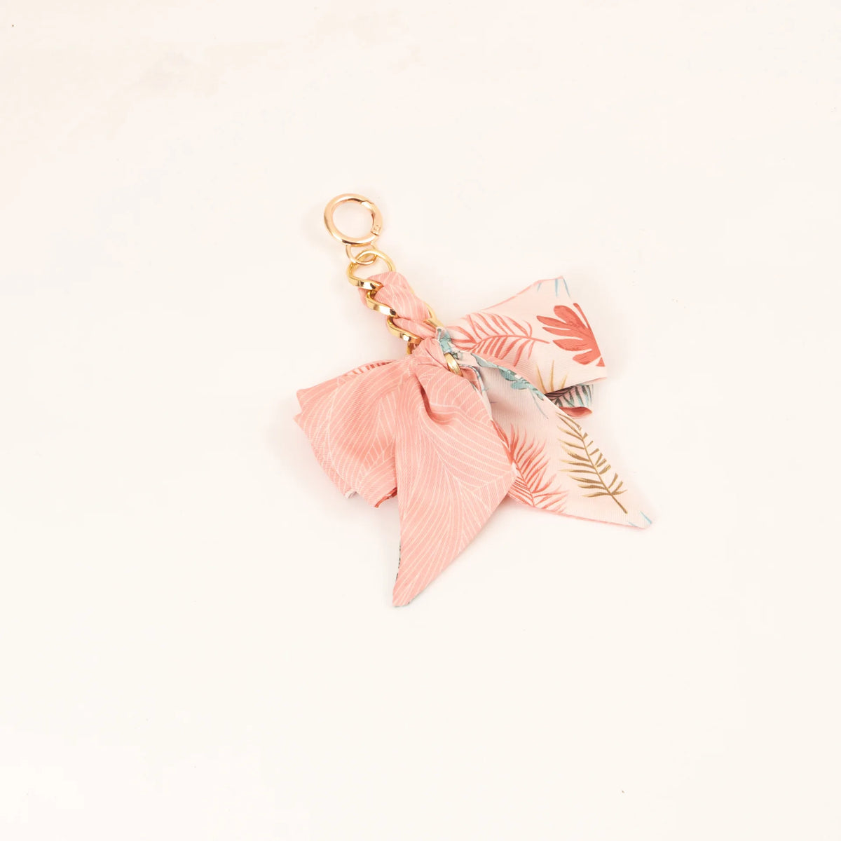 Llavero con lazo de cinta de seda rosa y hardware dorado con patrón floral.