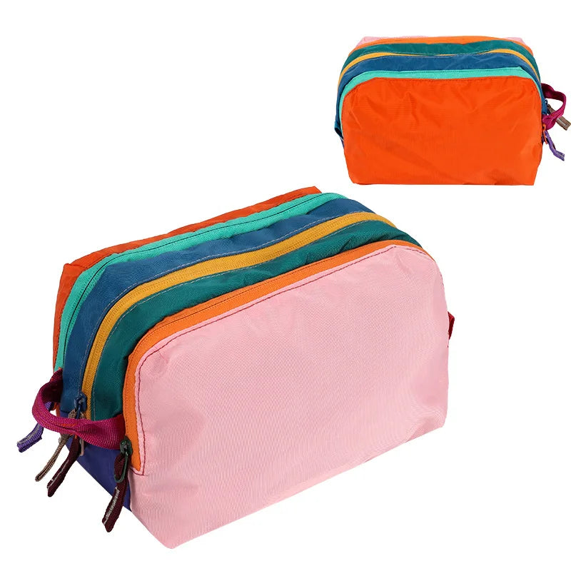 A multi-compartment travel toiletry organizer bag with colorful striped fabric and pink accents.
