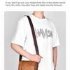 A man wearing a white t-shirt and jeans carrying a brown leather messenger bag across his body.