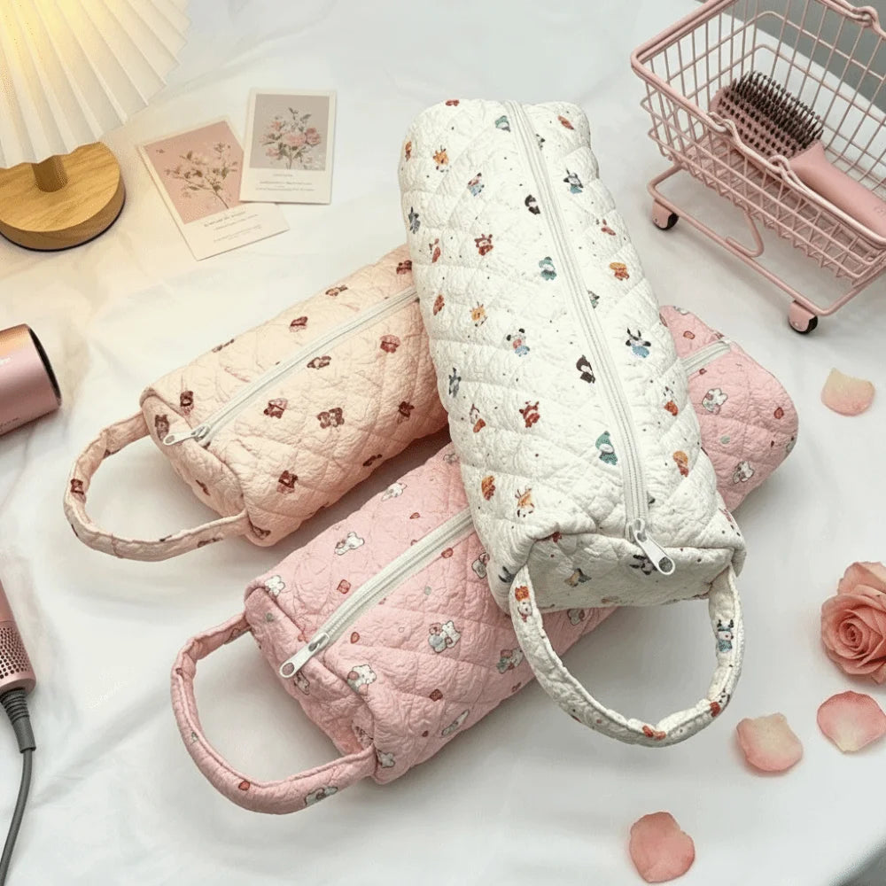 A collection of quilted storage bags in pink and white fabric are displayed on a white surface.