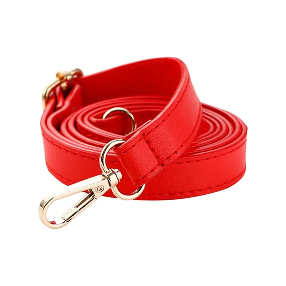 Sac à bandoulière en cuir rouge réglable avec boucle dorée.