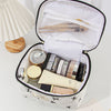 An open quilted makeup bag with various cosmetic products inside, resting on a white surface.