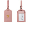 A pink PU leather luggage tag with a gold airplane design and a white identification strip.