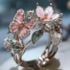 Silver rings featuring delicate pink and white flower and butterfly designs