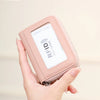 A hand holds a pink RFID protected accordion wallet designed for storing cards and IDs.