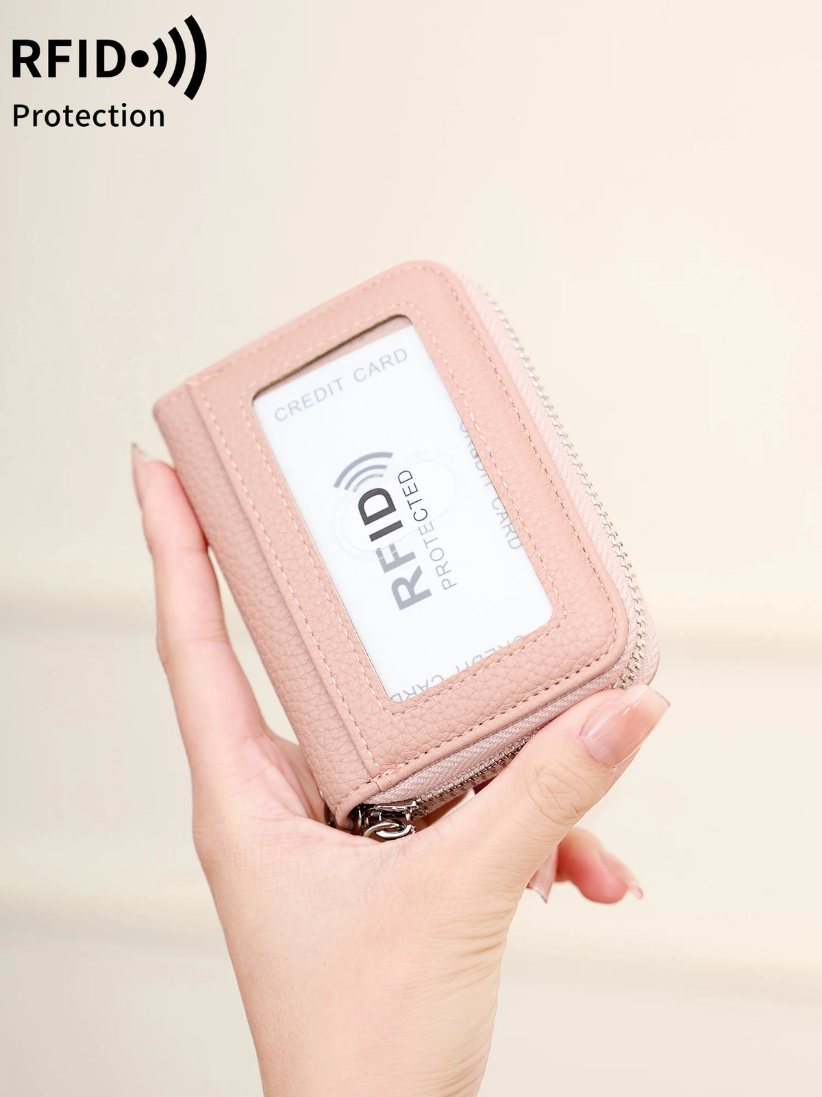 A hand holds a pink RFID protected accordion wallet designed for storing cards and IDs.