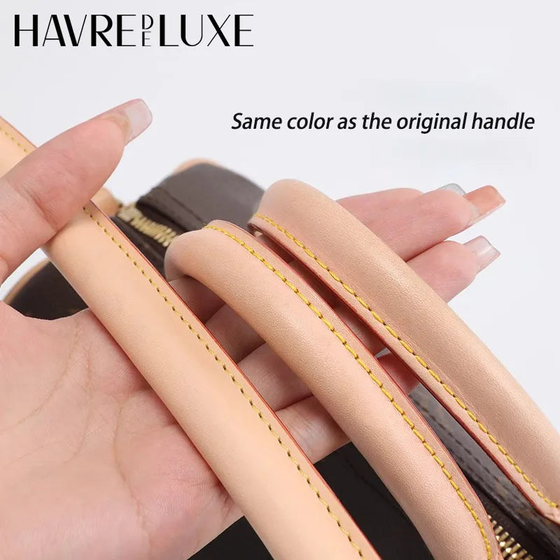 A hand holds a light tan leather replacement shoulder strap for a handbag, showing the color matches the original handle.