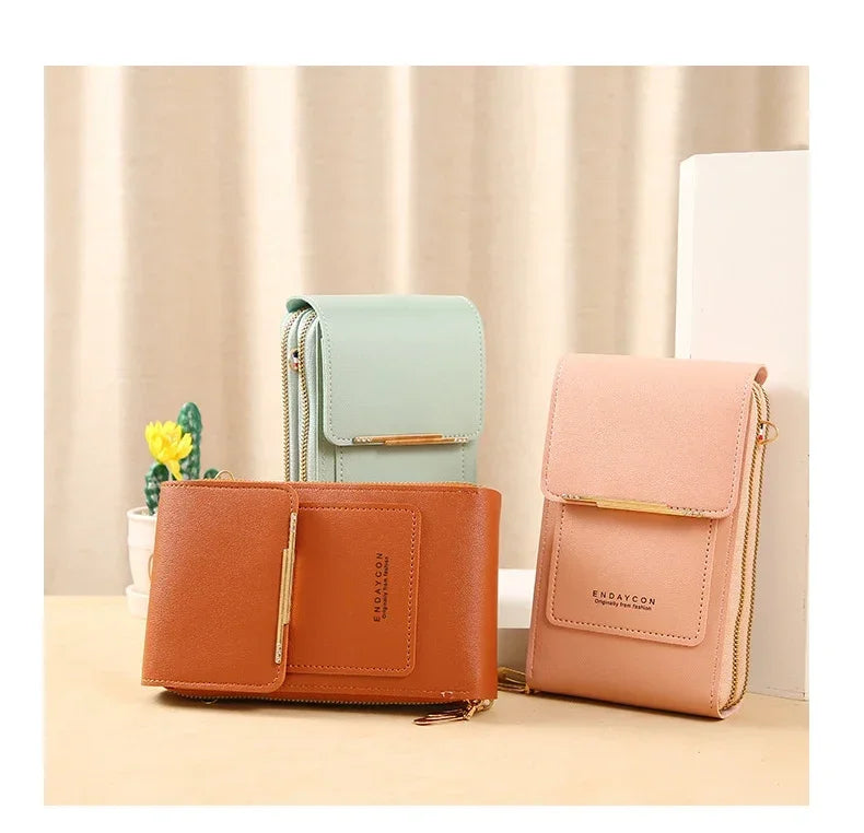 A collection of leather women's touch screen crossbody shoulder bags in shades of mint green, tan, and pink displayed on a li