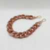 A close-up of a rose gold colored multicolor acrylic chain bracelet.